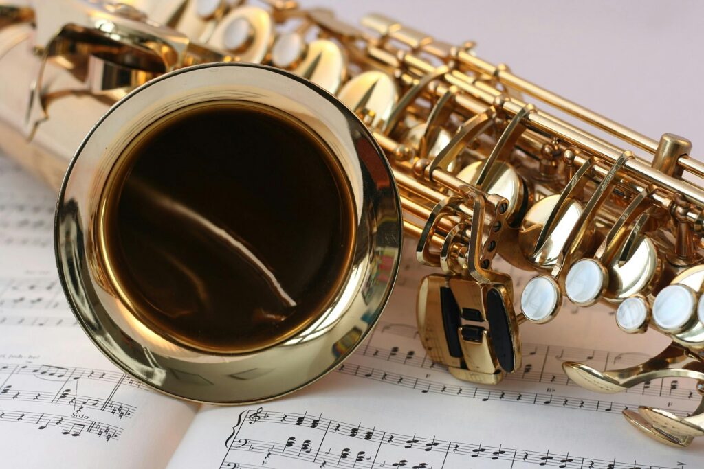 saxophone music gold gloss 45243 45243 A detailed view of a saxophone resting on sheet music, highlighting its brass finish.